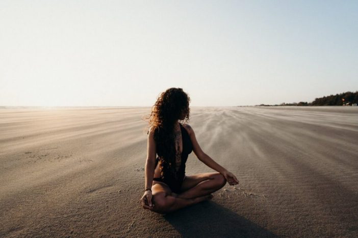 Vrouw op strand mediteren